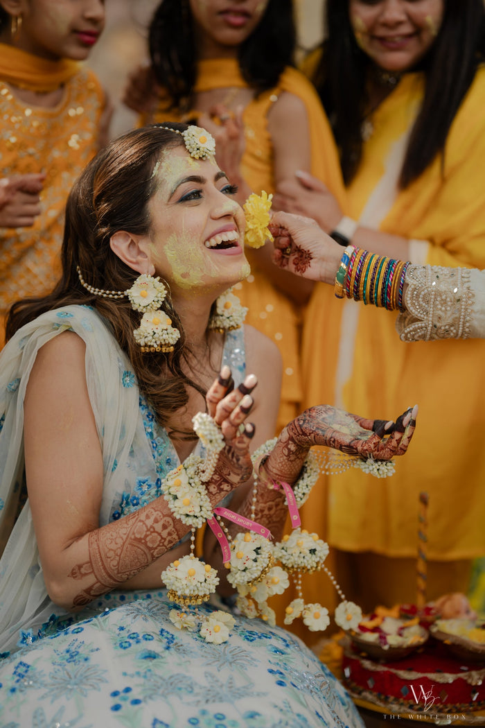 Close-up of handcrafted Noor floral Jhumkas earrings on an elite South Asian bride.