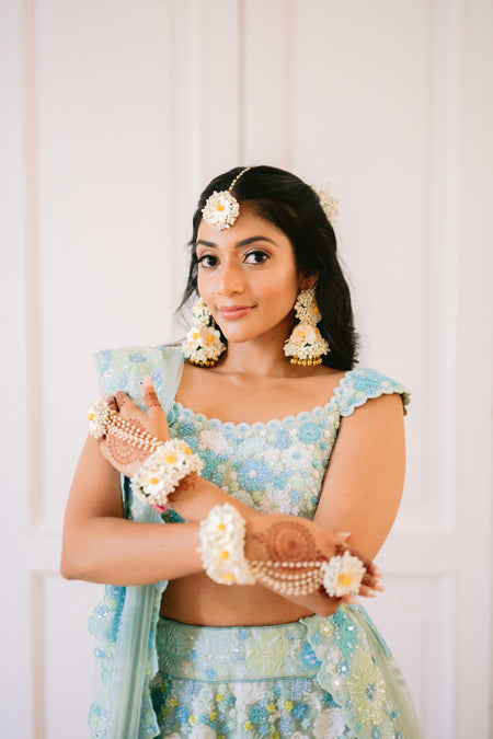 Real Prune bride wearing Whispers of Spring off-white floral jewelry set for her Haldi ceremony.