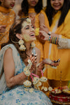 Close-up of handcrafted Noor floral Jhumkas earrings on an elite South Asian bride.