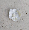 A close-up image of a bridal bangle with attached floral kaleere, featuring a intricate design with silk flowers and beads, held by a hand with nail art.